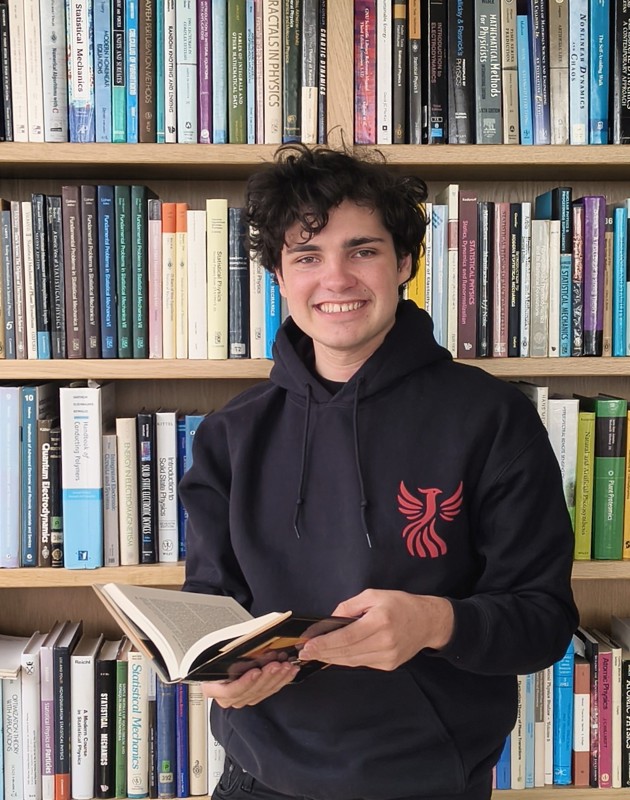 Yves Janssens Verlaak leest een boek in de bibliotheek.