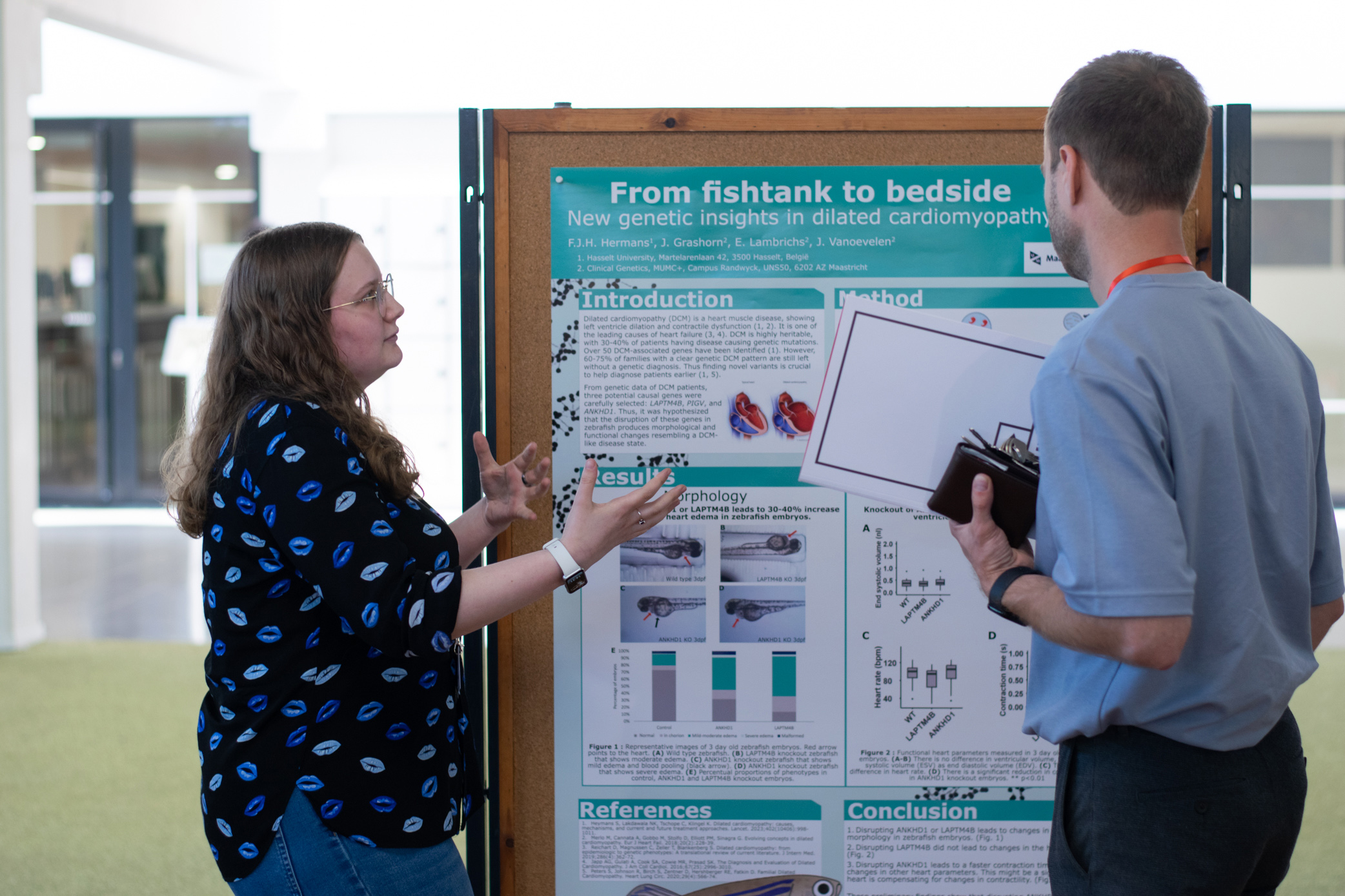 Student die uitleg geeft bij wetenschappelijke poster.