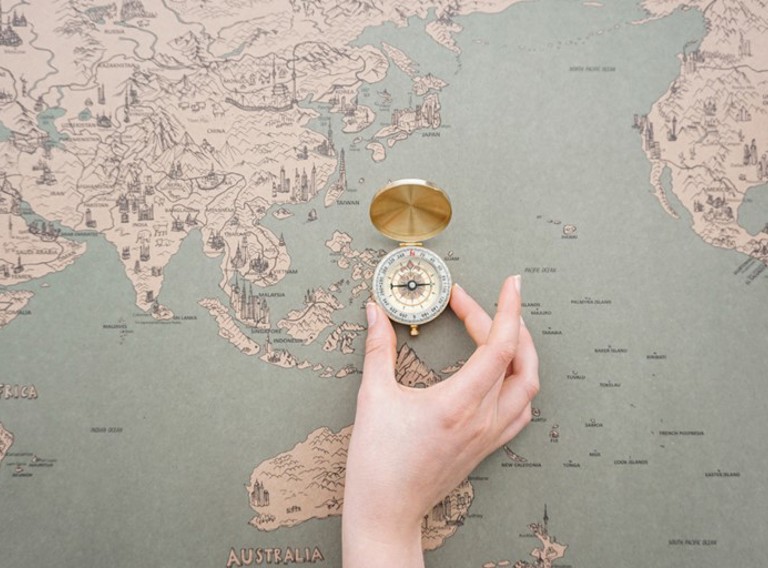 Hand Placing Compass World Map