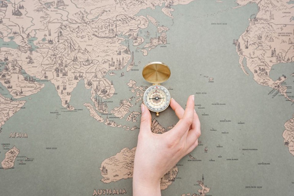 Hand Placing Compass World Map