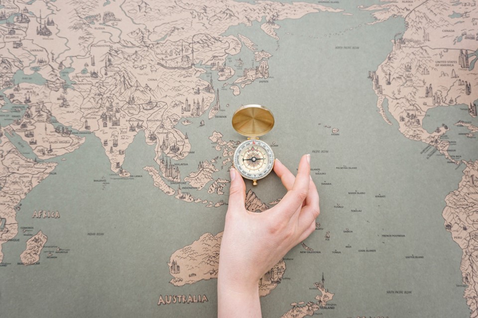 Hand Placing Compass World Map
