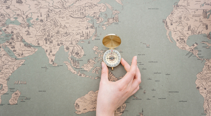 Hand Placing Compass World Map